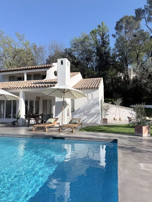 Villa blanche moderne à Grasse avec piscine privée, transats en bois, terrasse et vue sur les montagnes