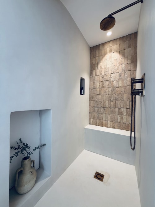 Salle de bain moderne avec douche pluie, mur en carrelage et design minimaliste blanc à la villa RJD Conciergerie à Grasse