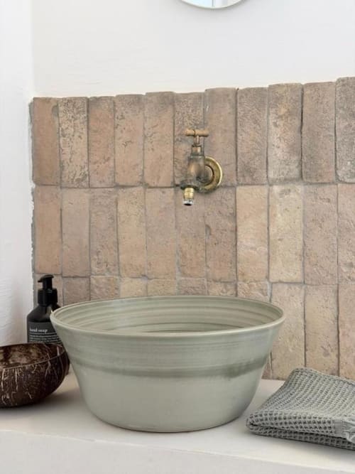 Bassin extérieur rustique avec robinet en laiton et carrelage taupe à la villa de Grasse