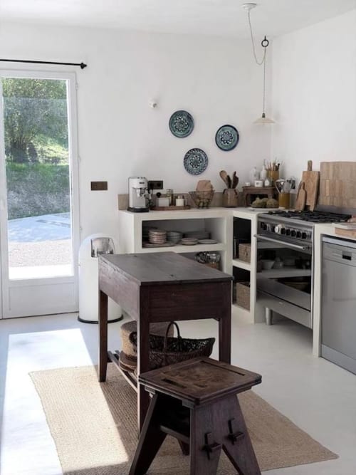 Cuisine moderne avec îlot en bois foncé, électroménagers en acier inoxydable et placards blancs à la villa Grasse