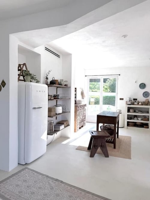 Cuisine de villa moderne à Grasse avec électroménagers blancs, étagères ouvertes, meubles en bois foncé et vue sur le jardin