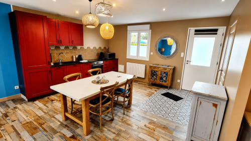 Cuisine-salle à manger moderne à la villa Ô de Mer à Sangatte avec mobilier rouge, table en bois et vue sur le jardin