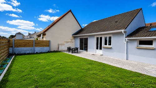 Villa blanche moderne avec jardin à Ô de Mer, Sangatte. Vaste pelouse, mobilier de patio et propriété côtière près de la plage.