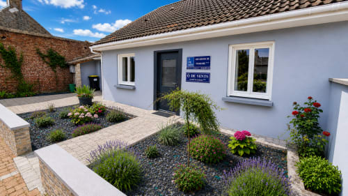Jardin de la villa Ô de Vents à Sangatte avec fleurs colorées, plantes, terrasse pavée et entrée