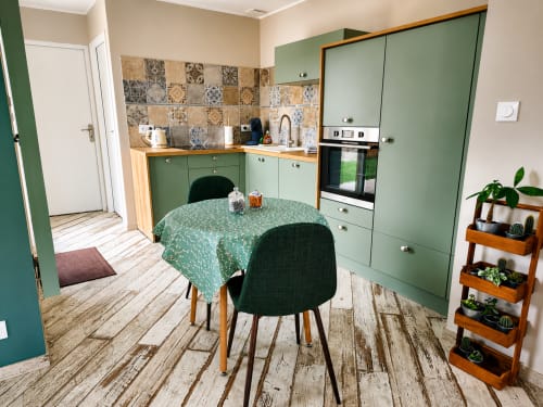 Cuisine-salle à manger moderne de la villa Ô de Mer près de la plage de Sangatte, avec mobilier vert, carrelage motifs et coin repas