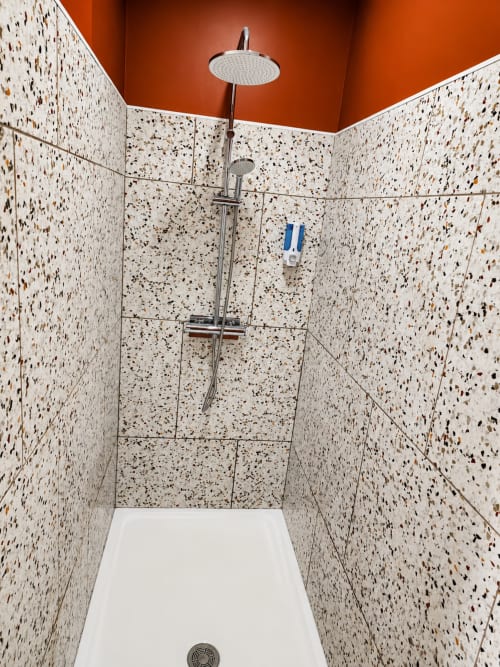 Douche moderne avec carrelage en terrazzo et pomme de douche effet pluie à la villa Ô de Mer à Sangatte, France