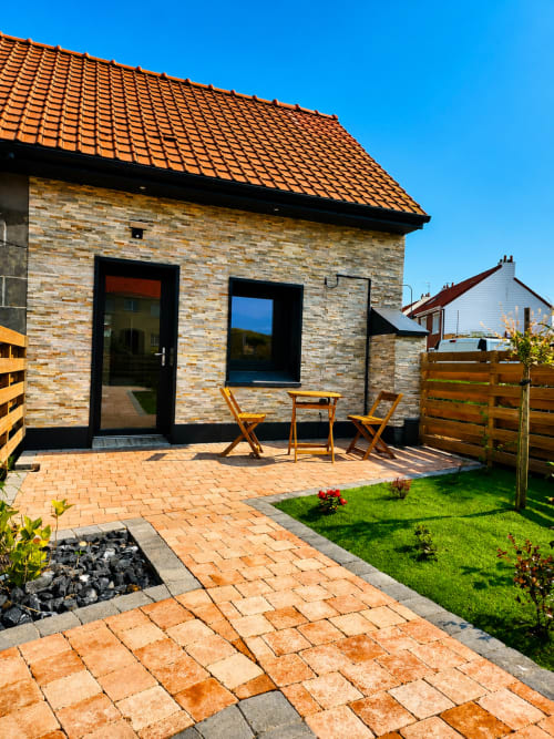 Villa moderne en brique avec toit de tuiles orange, coin détente et jardin à l'hôtel Ô de Mer à Sangatte