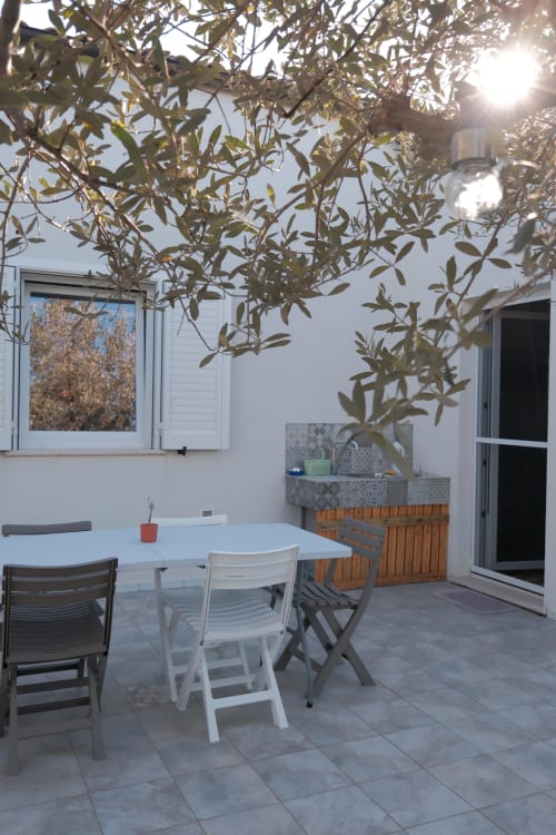 Outdoor dining area at Casa Verde Oliva apartment in Rocca San Giovanni with table, chairs, and olive tree