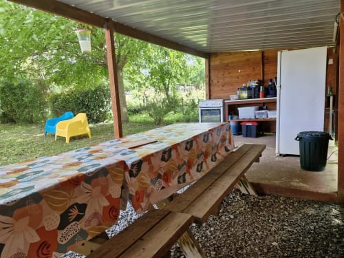 Pavillon couvert extérieur à La Petite Ferme De Pouillon avec table de pique-nique, kitchenette et vue sur le jardin