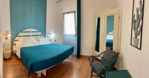 Handcrafted bedroom at Noemi Holiday House in Agnone Bagni with teal accent wall, double bed and sea views