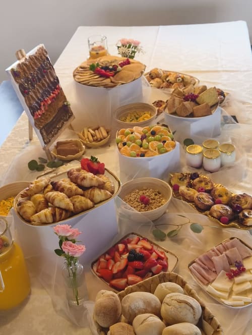 Elegante café da manhã na Casa da Mãe Ju com croissants, frutas frescas, doces, bolo de chocolate e bebidas