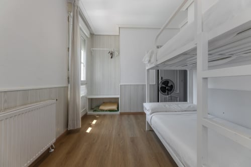 Habitación luminosa con literas, piso de madera y ducha en Hostal Costa Coruña, A Coruña, España