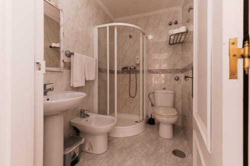 Baño moderno con cabina de ducha, inodoro y bidé en Hostal Costa Coruña, A Coruña