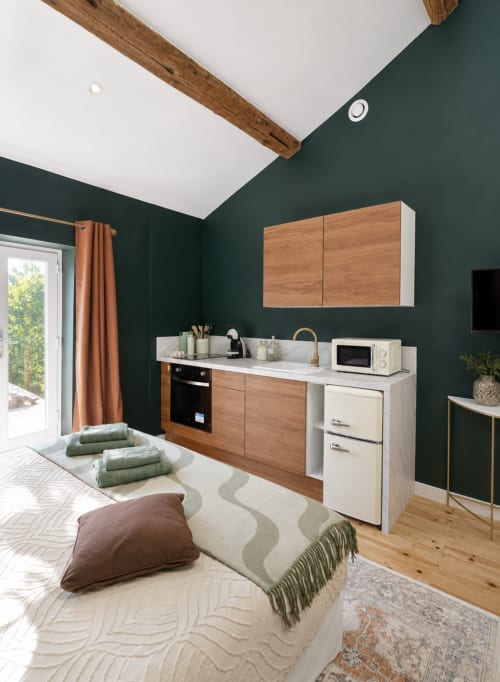 Kitchenette moderne de la Suite Sunan à la Bastide la Mourelette, Toulon, aux murs vert foncé, mobilier en bois et design compact