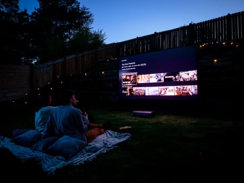 Los huéspedes disfrutan de una proyección de cine al aire libre en el Hostel Yasi de Lyon, relajándose sobre mantas bajo el cielo nocturno.