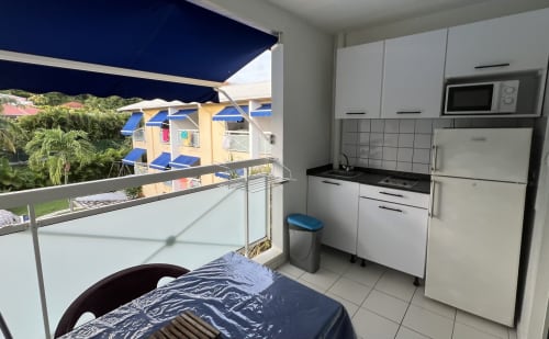 Angolo cottura con vista sulla piscina a Les Créolines, Sainte-Luce, cucina attrezzata e vista sul giardino tropicale