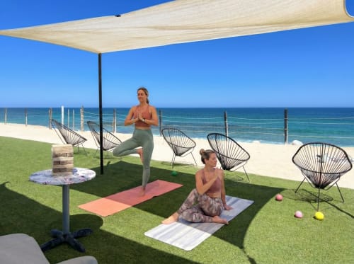 Dos mujeres practicando yoga en el jardín frente al mar de Vidasoul en La Vinorama, México, con vista al océano