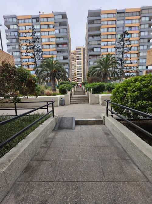 Pasarela peatonal con barandillas hacia modernos edificios de departamentos en Your Place Spa, Antofagasta, Chile