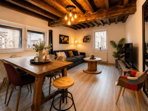 Appartement cosy au Systeo BnB à Châtillon-sur-Chalaronne avec poutres apparentes, table à manger, canapé et vue sur la ville