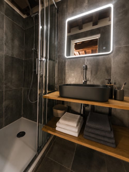 Salle de bain moderne à Systeo Chatillon sur Chalaronne avec lavabo noir, miroir LED, meuble-vasque bois et douche