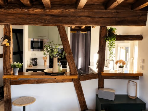 Cuisine chaleureuse de l'appartement Systeo B&B à Châtillon-sur-Chalaronne, avec poutres en bois apparentes et équipements modernes