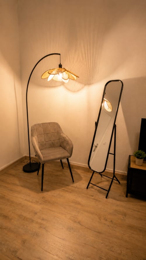 Espace salon moderne à Systeo Mâcon avec lampadaire arc, fauteuil rembourré et miroir sur pied sur parquet