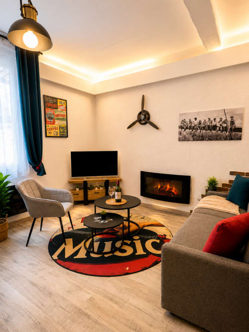 Séjour moderne de l'appartement Systeo Mâcon avec cheminée, TV, mobilier élégant et tapis à motifs musicaux