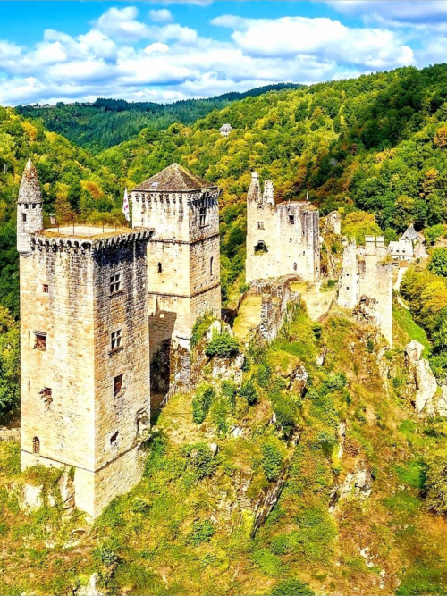 Medieval castle ruins nestled in lush forested hills, Les Murmures du Bois near Camps Saint Mathurin Léobazel, France