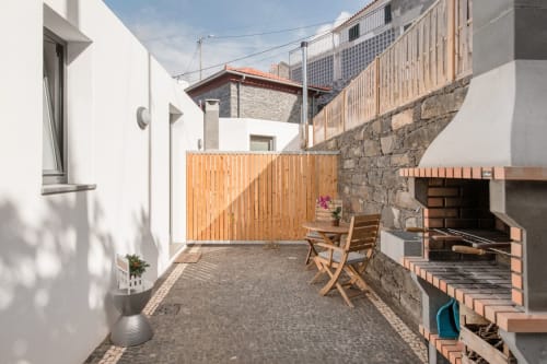 Pátio exterior com churrasqueira e mesa de refeições