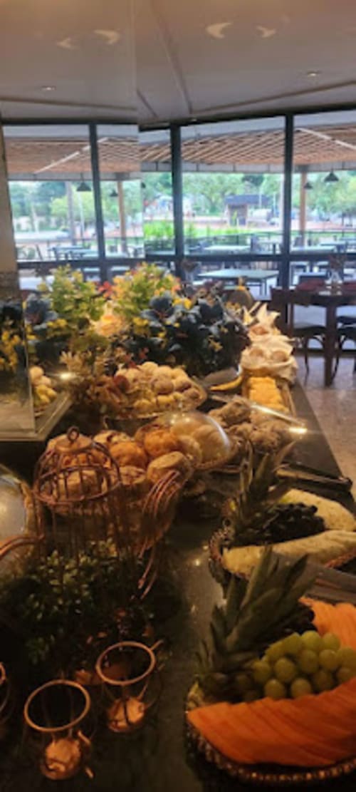 Mesa de buffet no apartamento Wellington Rodovalho em Goiânia com vista da cidade através de janelas do piso ao teto