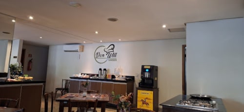 Cozinha do restaurante Don Jau no apartamento Wellington Rodovalho, Goiânia com mesa de refeições e eletrodomésticos