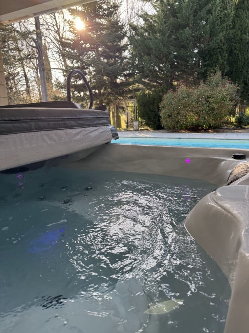 Bain à remous aux lumières bleues du Domaine de Bize, avec vue sur le jardin et équipements de piscine à Mirepoix