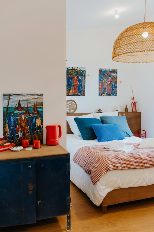 Chambre colorée aux écuries du bout du monde, Landunvez, avec coussins bleus, lampe suspendue tissée et décor nautique