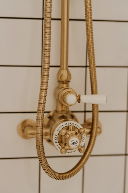 Robinet de douche en laiton vintage avec poignées en porcelaine aux Écuries du Bout du Monde, Landunvez