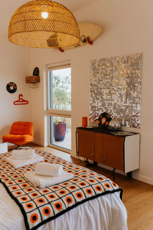 Chambre rétro aux Écuries du Bout du Monde à Landunvez, décorée d'accents orange et de motifs géométriques