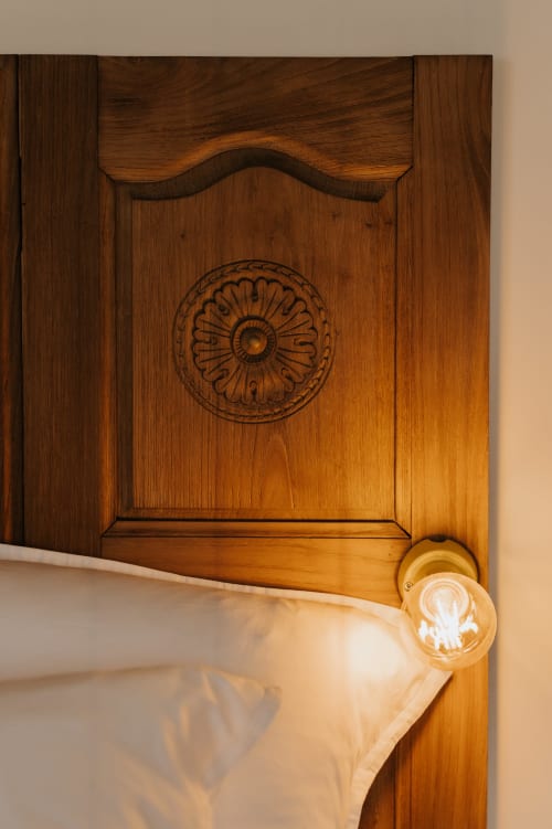 Porte en bois ornée avec détail de rosace sculptée à la Chambre Bretonne aux Écuries du bout du monde, Landunvez
