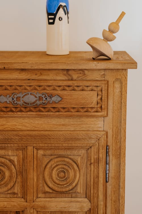 Commode en bois aux détails sculptés décorés et figurine d'oiseau bleu dans la Chambre Breton aux écuries du bout du monde