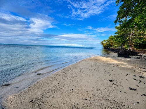 Plage de sable blanc immaculé, eaux turquoise et végétation tropicale luxuriante au Maatea Tropical Lodge, Polynésie française