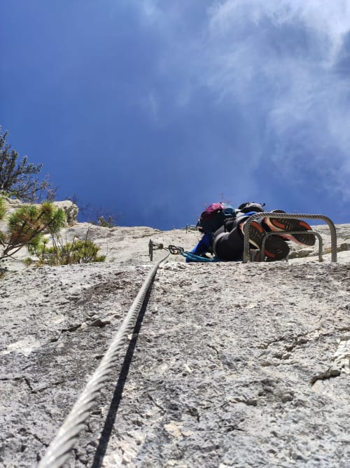 Mountain climber with gear at rest stop near Puget-Théniers, France during summit attempt