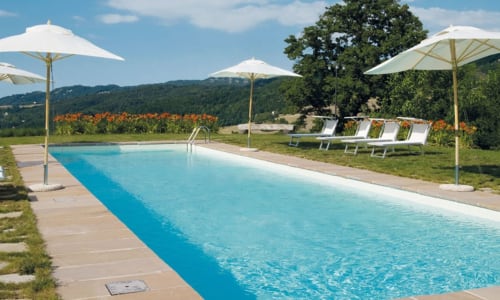Piscina di Lodole Country House a Monzuno con lettini, ombrelloni e vista sulle montagne nella campagna toscana