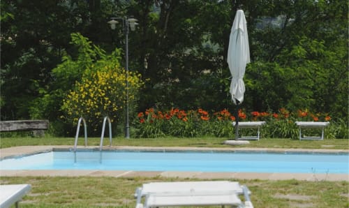 Piscina della Lodole Country House B&B a Monzuno con lettini prendisole, ombrellone e sfondo di giardino
