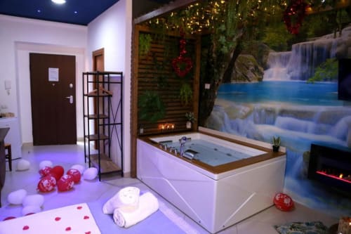 Vasca Magnolia Suite con decorazioni romantiche a cuore rosso e murale cascata presso The Flower Garden, Castellammare di Stabia