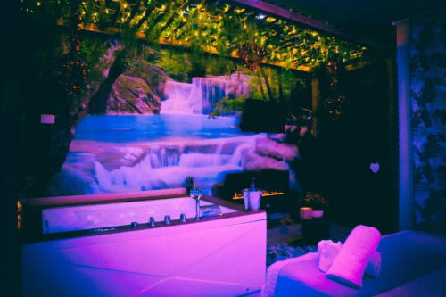 Suite Magnolia presso The Flower Garden B&B di Castellammare di Stabia con cascata illuminata al neon, DJ booth e dettagli rosa