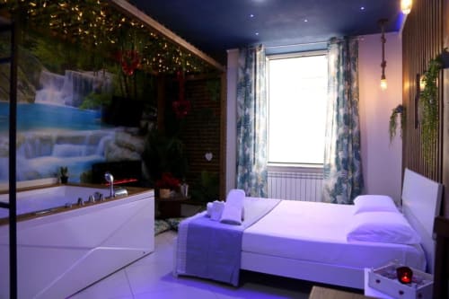 Suite Magnolia presso The Flower Garden BnB a Castellammare di Stabia: letto moderno con illuminazione ambientale viola, bianco