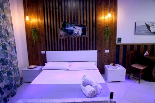 Camera Magnolia Suite presso The Flower Garden B&B a Castellammare di Stabia con letto bianco, testiera in doghe di legno e vista sulla città