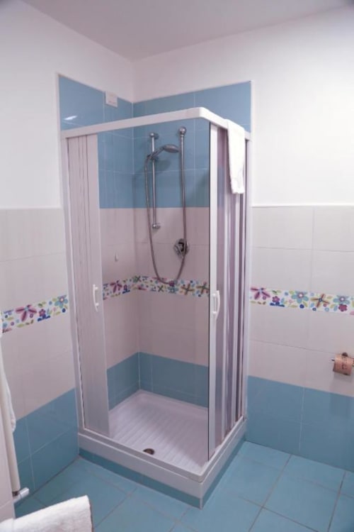 Moderno box doccia in vetro nella Suite Ortensia di The Flower Garden B&B a Castellammare di Stabia, con finiture blu e bianche