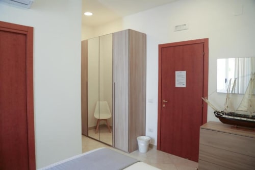 Camera moderna al B&B The Flower Garden con armadio specchiato, porte rosse e stile nautico a Castellammare di Stabia