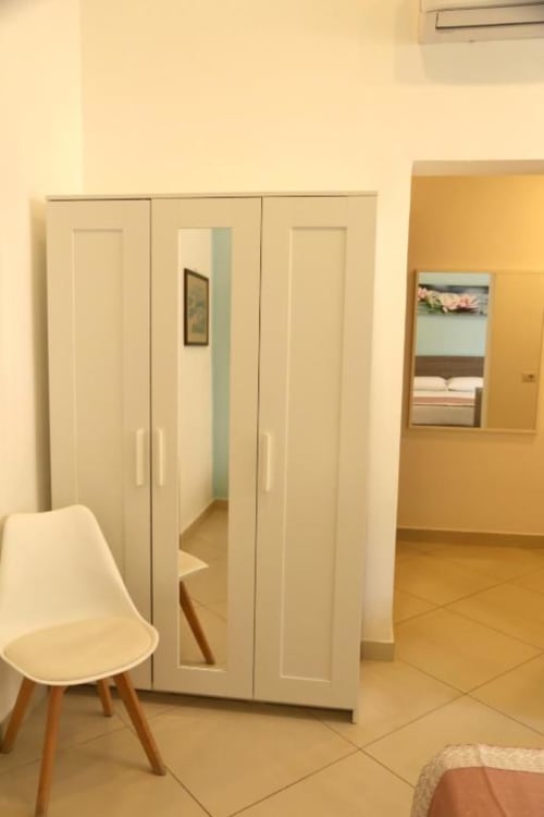 Armadio color crema con ante a specchio nella Triple Room Ortensia del The Flower Garden B&B, Castellammare di Stabia