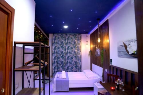 Suite Magnolia presso The Flower Garden a Castellammare di Stabia con letto moderno, illuminazione ambientale blu e vista sulla città