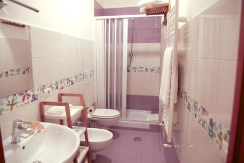 Bagno moderno della Lavanda Room presso The Flower Garden B&B, Castellammare di Stabia, con dettagli viola e doccia.